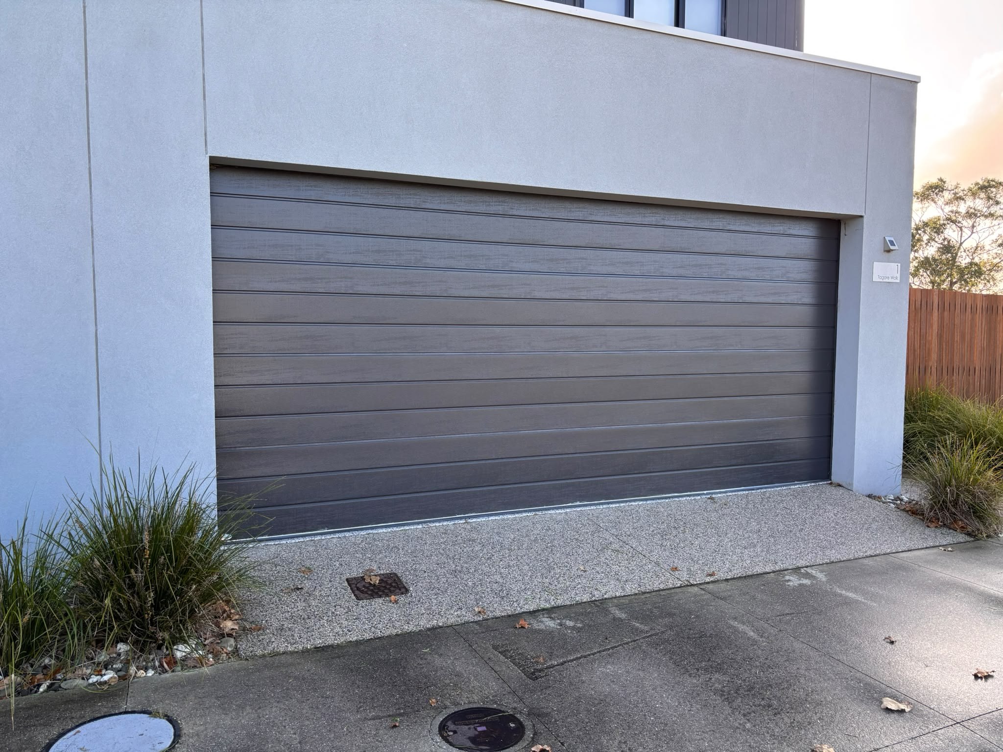 Grey sectional garage door on a modern home, from SG Garage Doors
